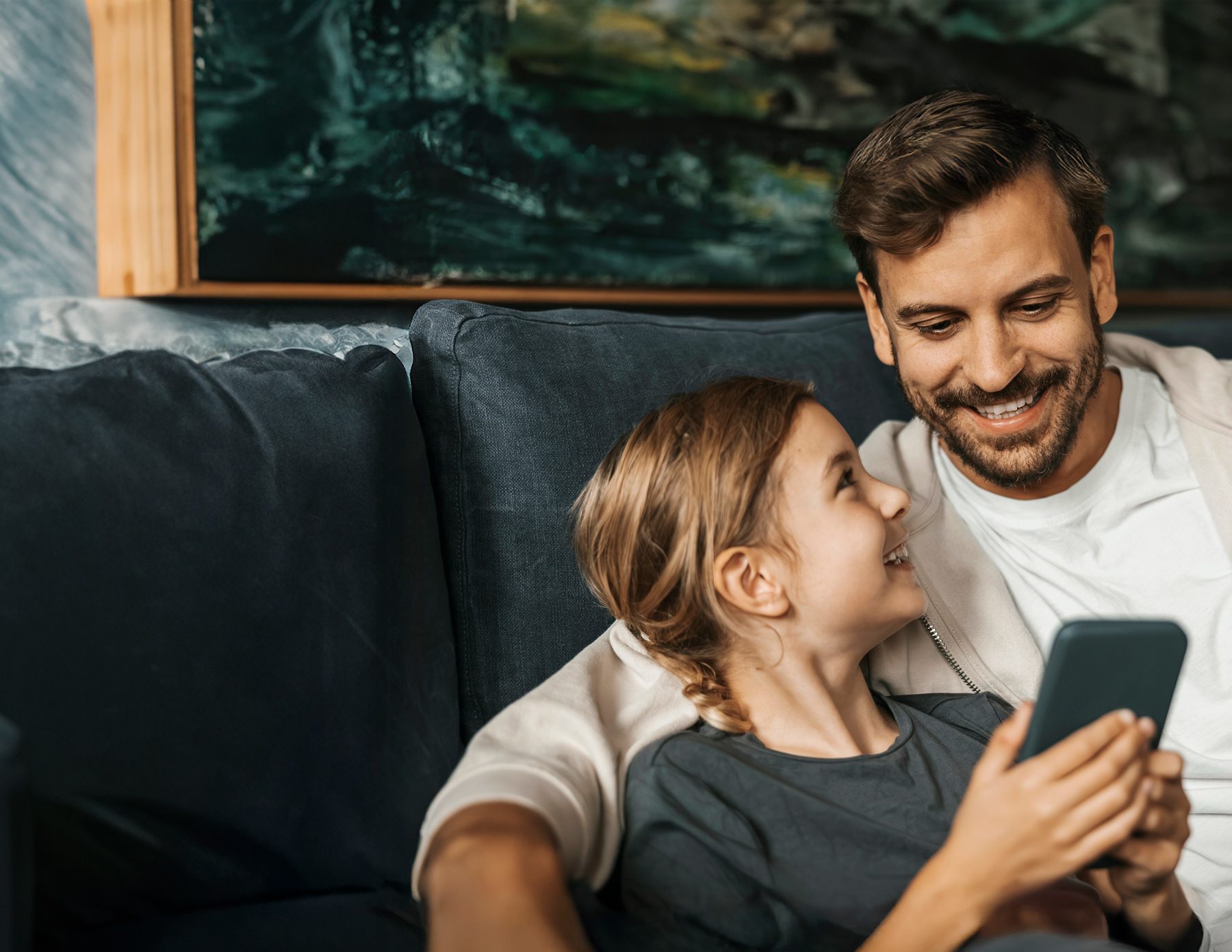 Pappa och barn håller i en mobiltelefon med Munipal avfallsappen i